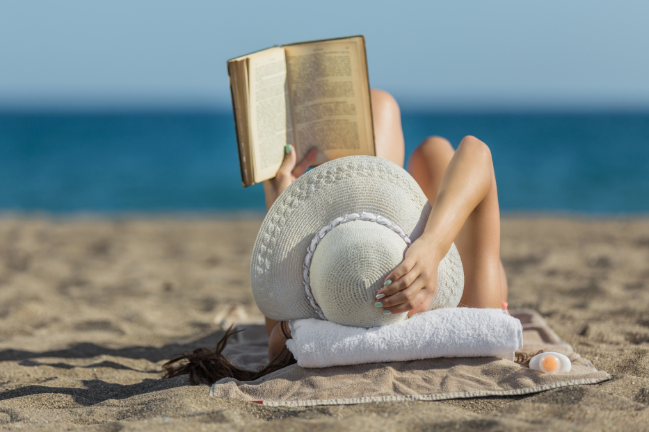 Frau liest am Strand ein Buch 