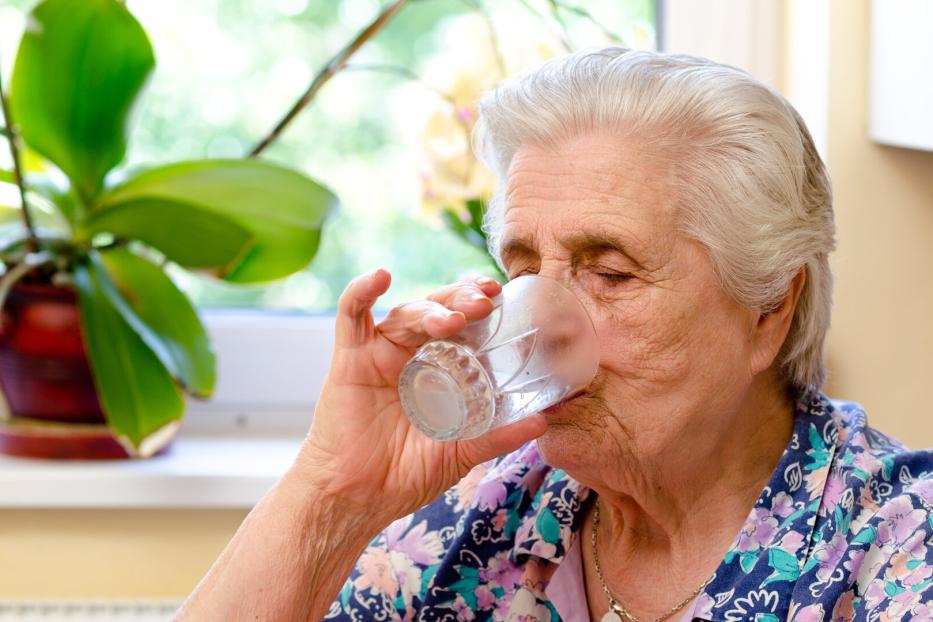 Eine Frau trinkt ein Glas Wasser