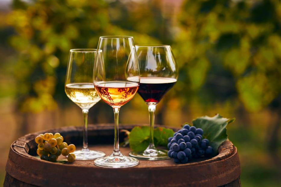 Three glasses of white, ros?É¬© and red wine and an old wooden barrel, with winery still life