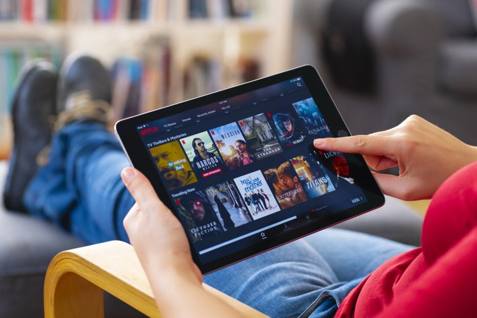 Netflix-User sucht auf einem Tablet nach einem passenden Film