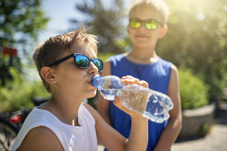 Bub trinkt Wasser aus der Flasche