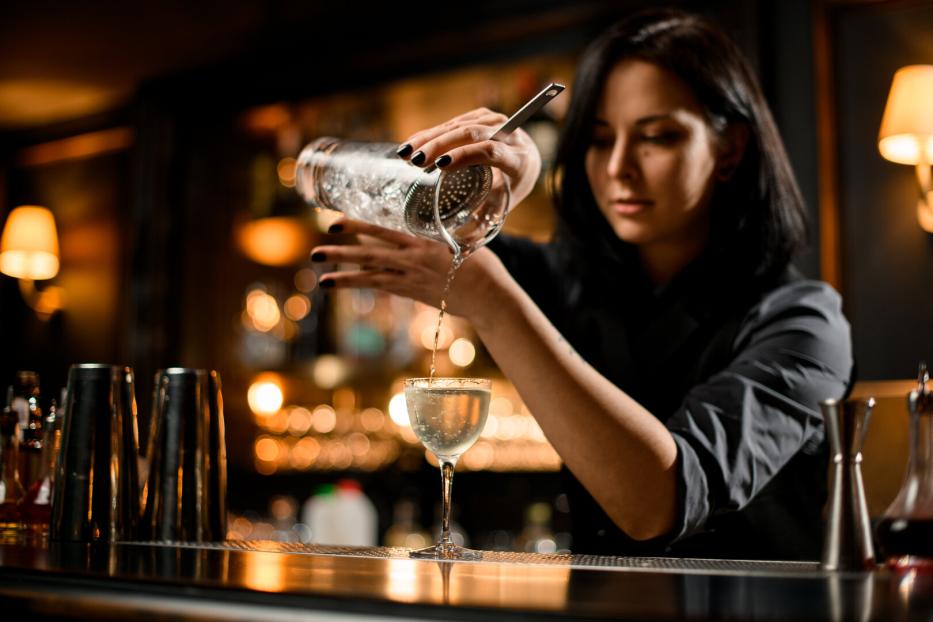 Barkeeperin mixt einen Drink