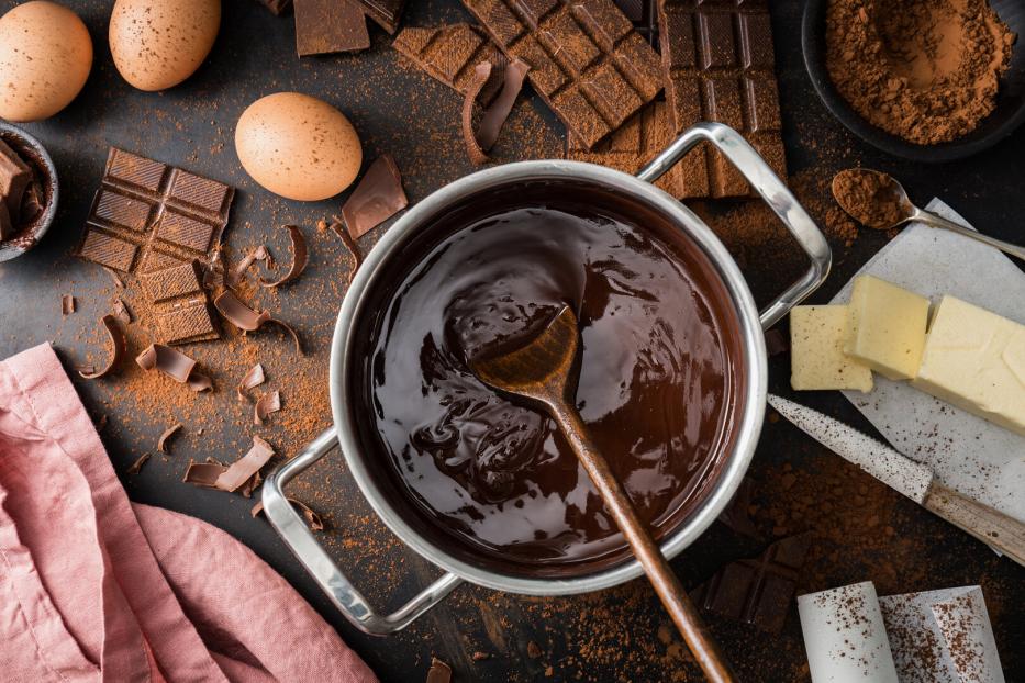 geschmolzene Schokolade im Topf mit Zutaten wie Butter und Eiern