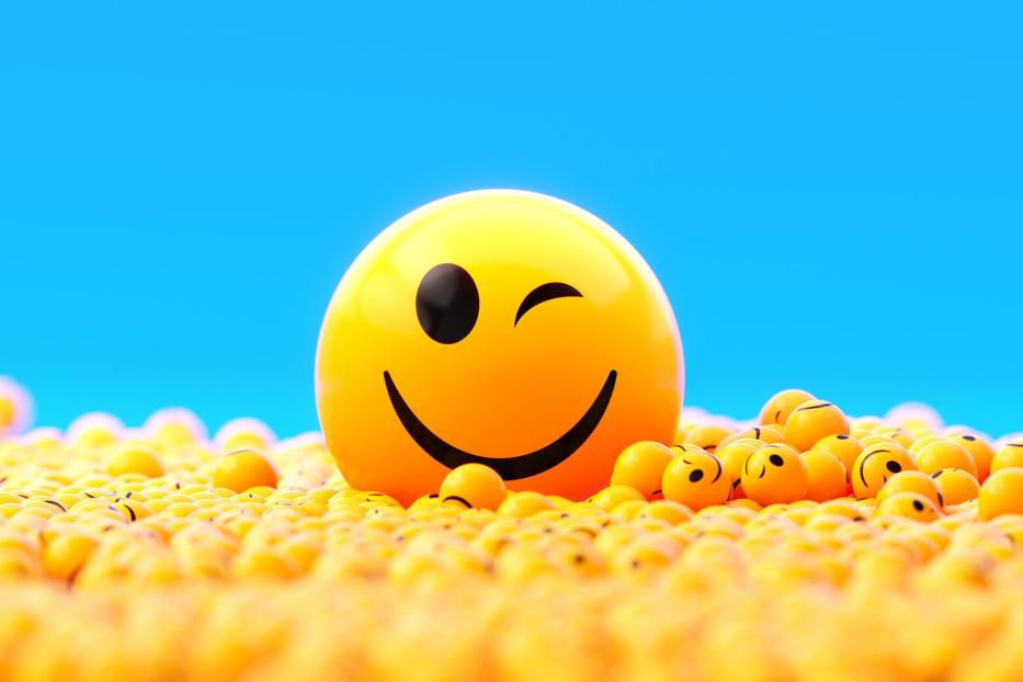 Yellow Spheres Textured With Happy Face Emoji On Blue Background