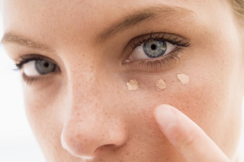 Frau trägt Concealer auf