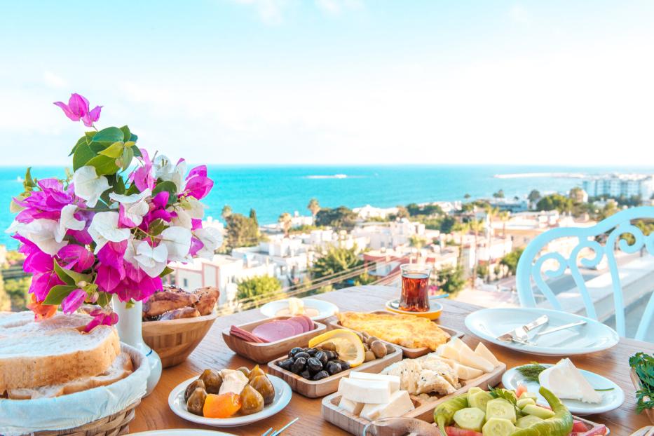 Breakfast on the beach at hotel or resort by the sea in summer season. Holiday and vacation breakfast image.	Traditional Turkish or Greek breakfast at bodrum town beach in Turkey or Greece
