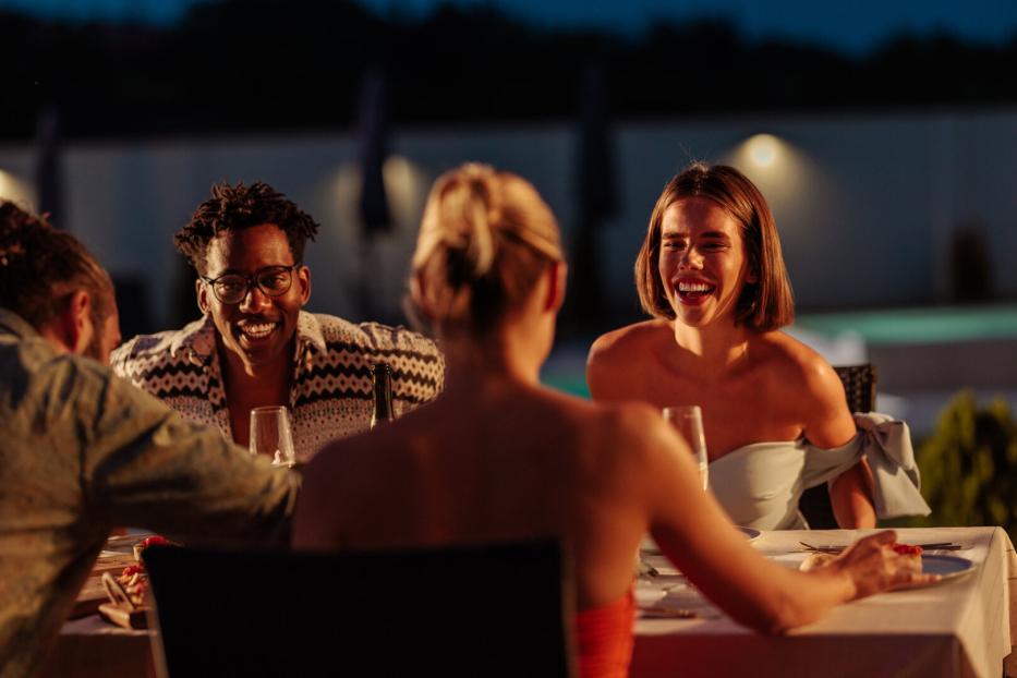 Friends enjoying dinner together at luxury resort