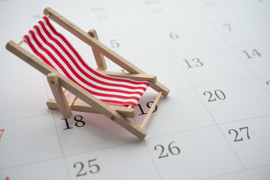Red beach chair on white blank calendar background copy space.