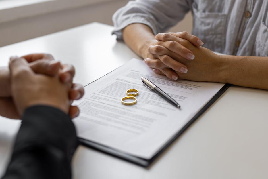 Partner sitzen gegenüber am Tisch liegt ein Vertrag