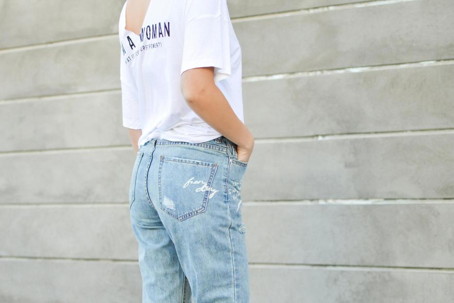Eine Frau trägt Jeans und ein weißes T-Shirt.