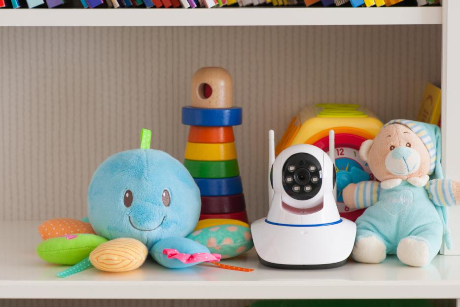 IP camera on the shelf with toys, serving as a baby monitor