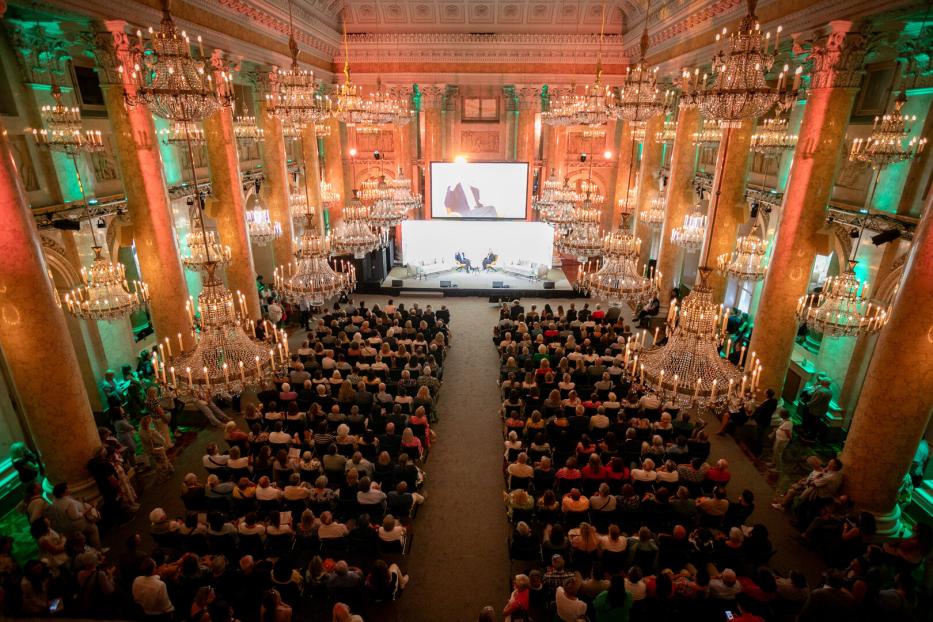 Ein großer Saal der Wiener Hofburg mit Lustern und vielen Menschen