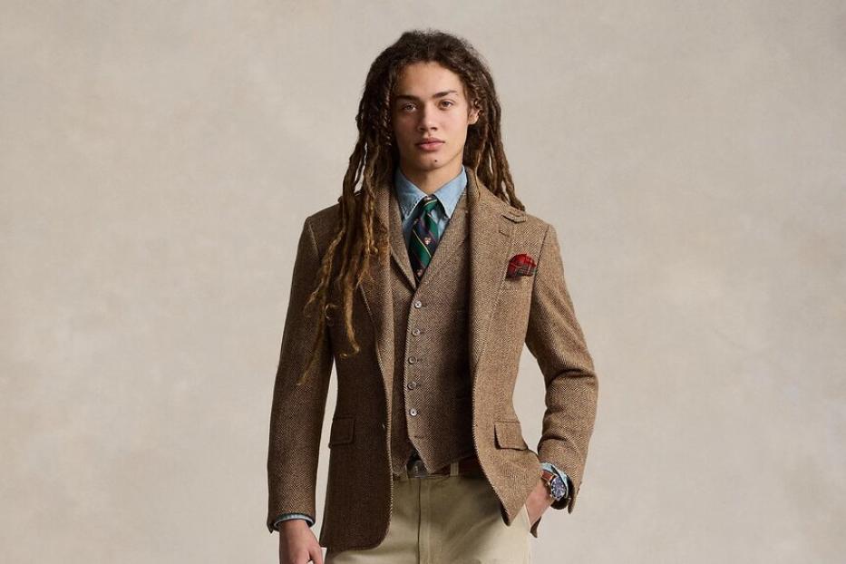 Ein Mann mit Dreadlocks trägt ein Tweed-Sakko und eine passende Weste.