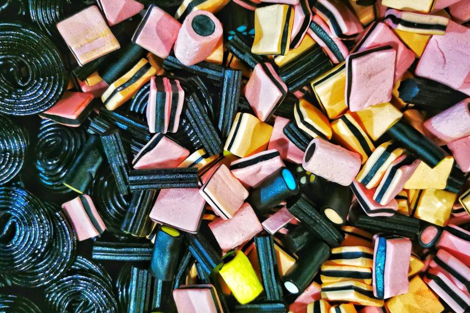 Eine bunte Mischung aus Lakritzschnecken und Lakritzkonfekt in verschiedenen Formen und Farben liegt durcheinander.