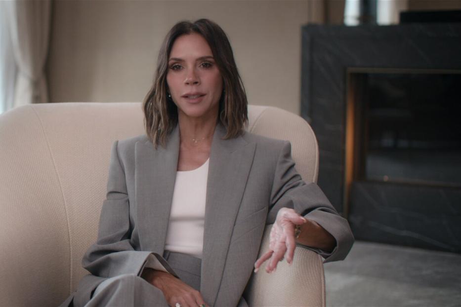 In der Netflix-Serie zeigt sich Victoria Beckham im grauen Blazer und weißem Shirt. 