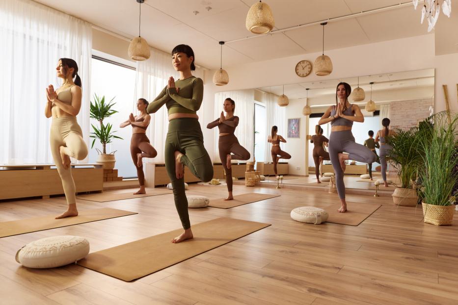 Frauen, die in einem Studio Yoga betreiben