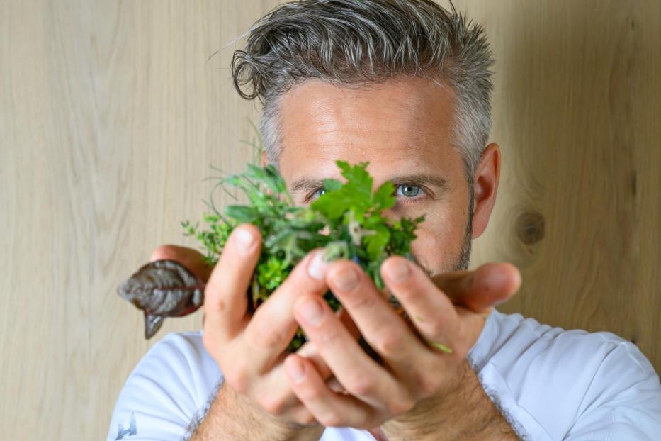 Mann hält sich Kräuter vors Gesicht