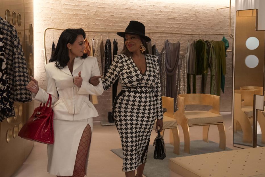 Kim Kardashian im Blazer, Rock und Netzstrumpfhosen, an ihrer Seite Niecy Nash. Eine Szene aus "All's Fair".