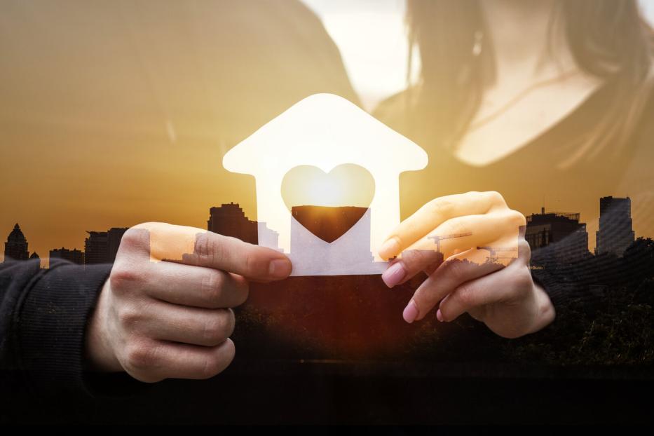 Paar hält das gemeinsame Haus in Händen.