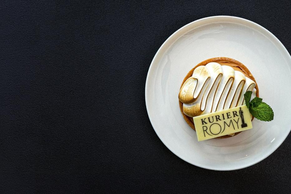 Ein kleines Küchlein mit einem Kurier-Romy-Schokoblättchen und einem Minzblatt.