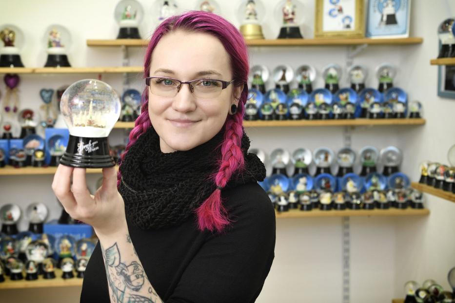 Junge Frau mit Schneekugel und roten Haaren