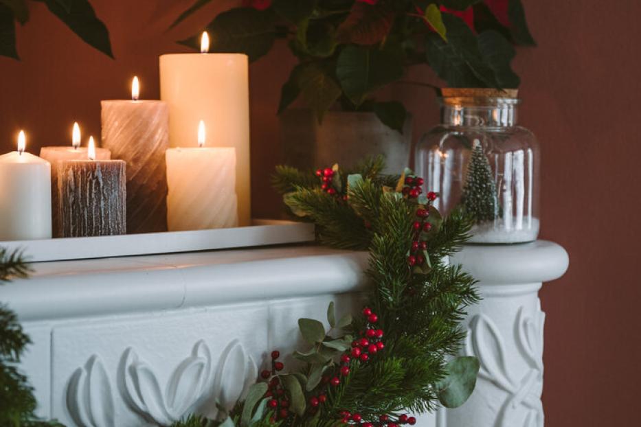 Ein mit Kerzen geschmückter, weinachtlicher Kamin.
