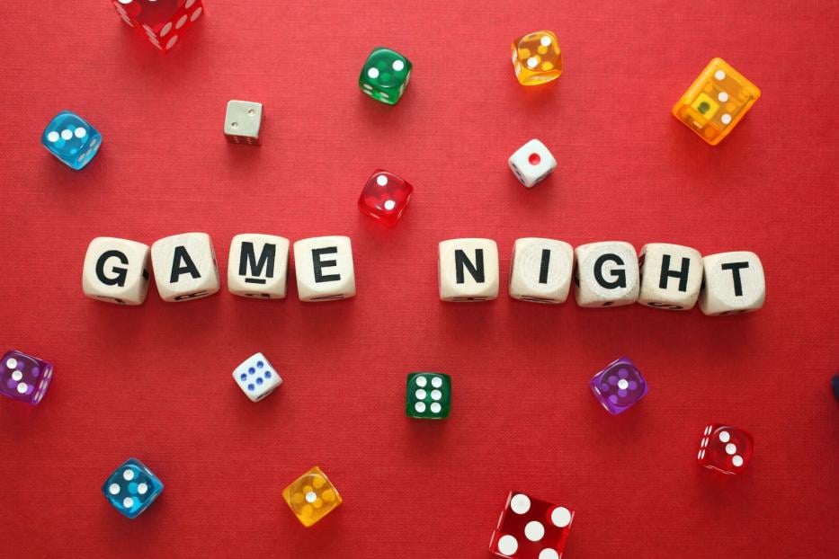 Wooden word dice spell 'Game Night' with multicoloured dice around it.