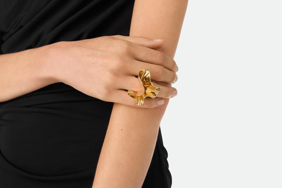 Zwei verschränkte Hände mit einem goldenen auffälligen Ring auf einer Hand