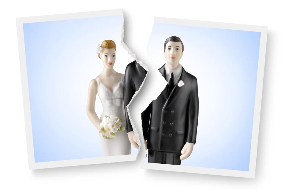 Divorce. Torn photograph of wedding cake topper.