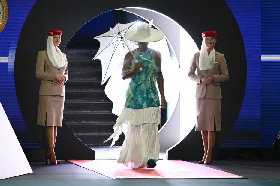 Naomi Osaka betrifft mit mit Hut und Schirm den Centercourt.