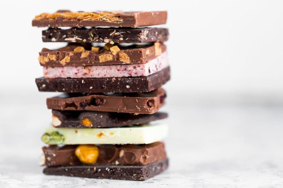 Mehrere unterschiedlich gefüllte und geschichtete Schokoladentafeln sind übereinander gestapelt.