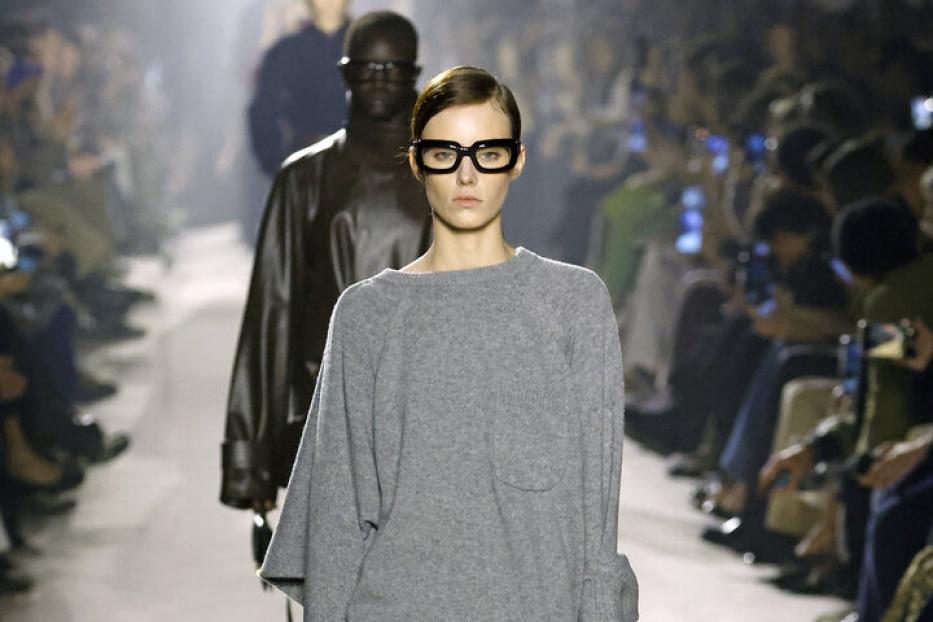 Model im langen grauen Pulli mit halterlosen Strümpfen auf dem Laufsteg