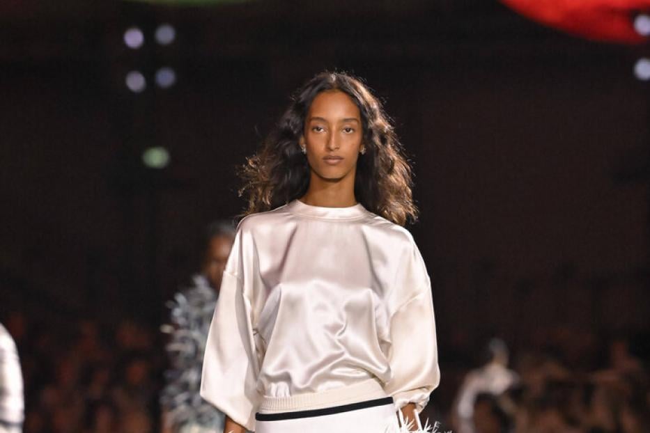 Weißes Satin-„T-Shirt“ zum exzentrischen Rock mit weißen Federn. 