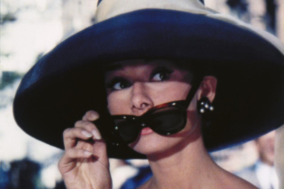 Audrey Hepburn mit Hut und Sonnenbrille im Film "Frühstück bei Tiffany".