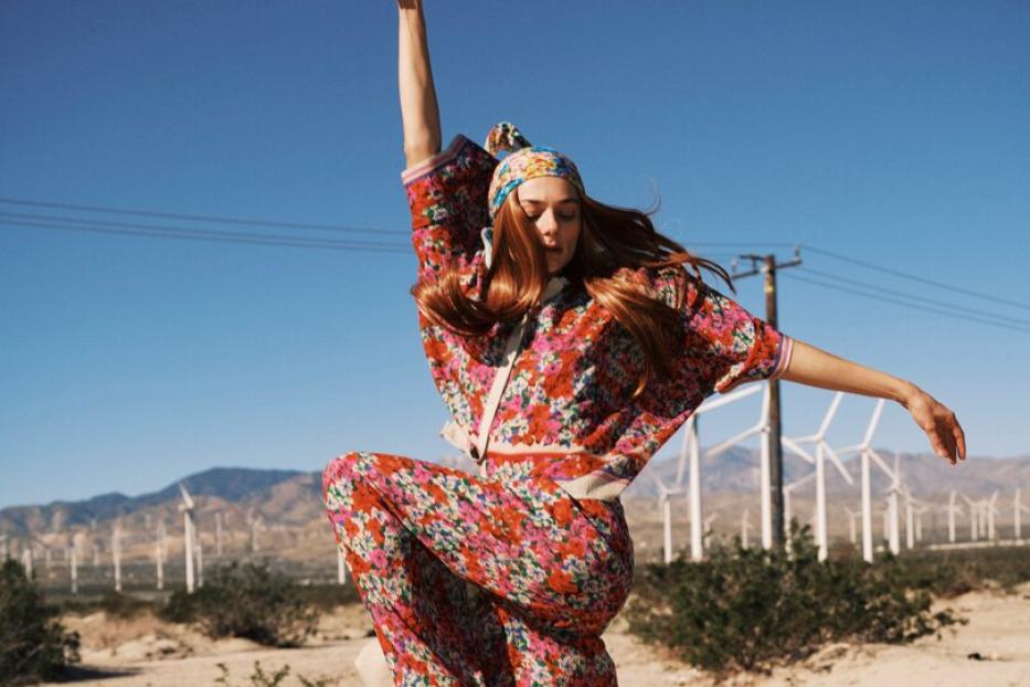 Eine Frau in der Wüste mit einem Blumen-Einteiler