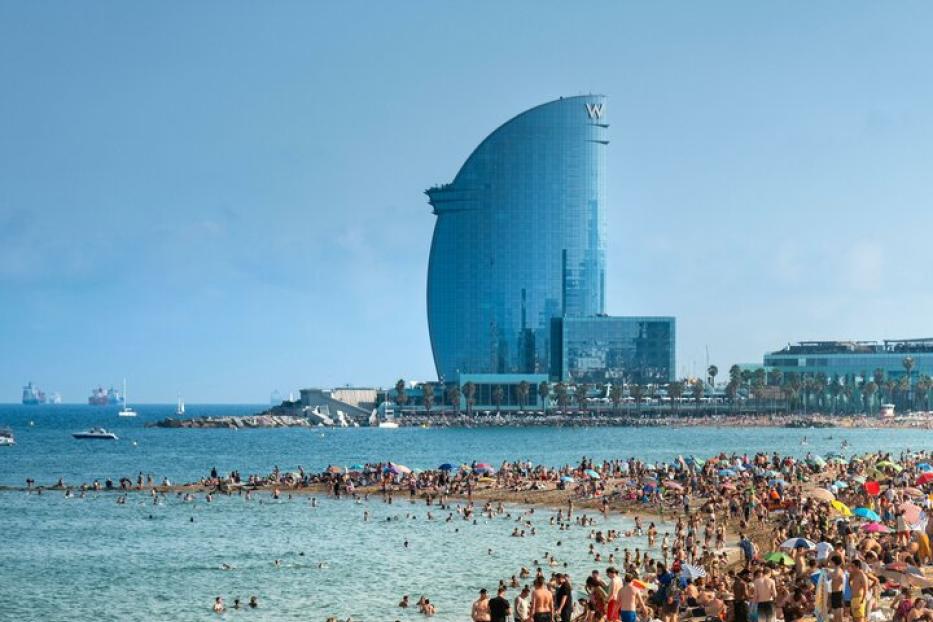 Ein Strand in Barcelona mit einem bekannten Hotel im Hintergrund