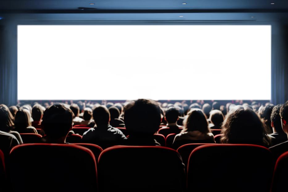 People in the cinema hall with empty white screen.