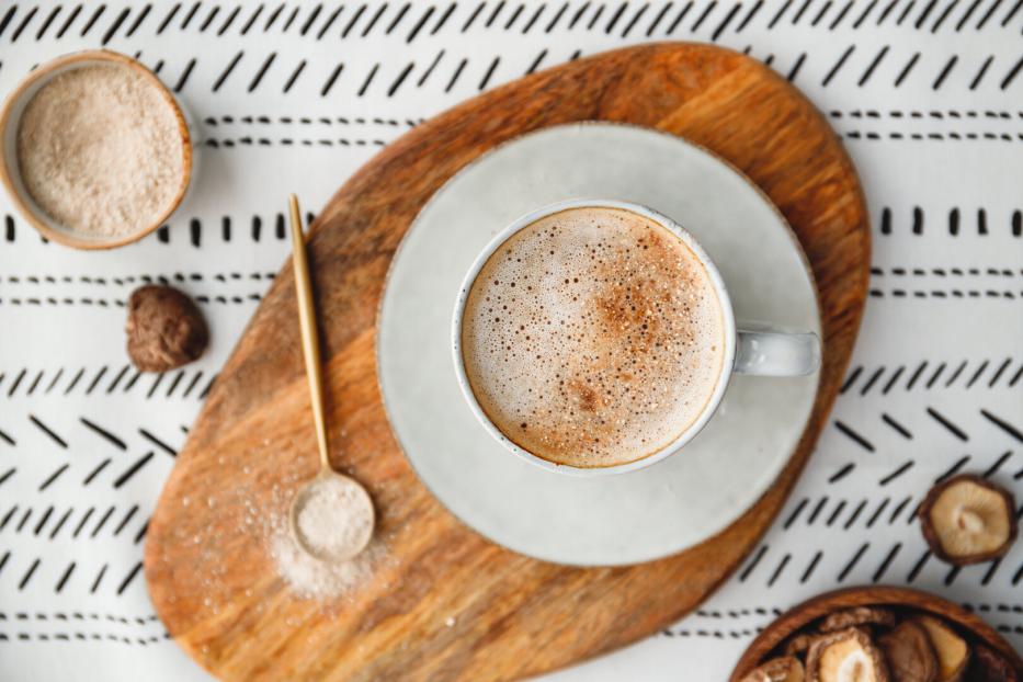 Top view of mushroom latte with Shiitake powder and unsweetened coconut-almond blend milk. Healthy useful vegan drink, flat lay.