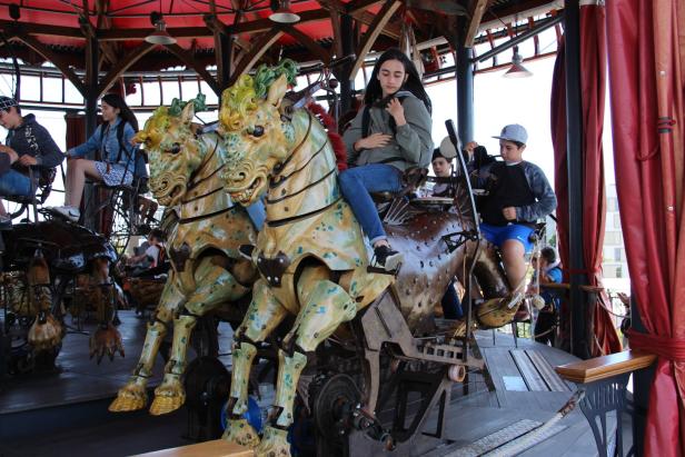 Kinder fahren auf einem Karussell mit mechanischen Pferden.