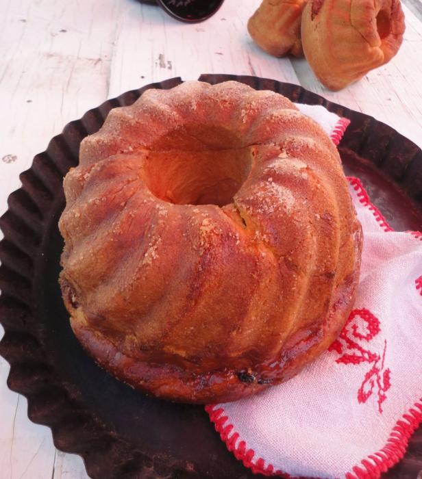 Ein Gugelhupf liegt auf einem Teller mit einer Serviette.