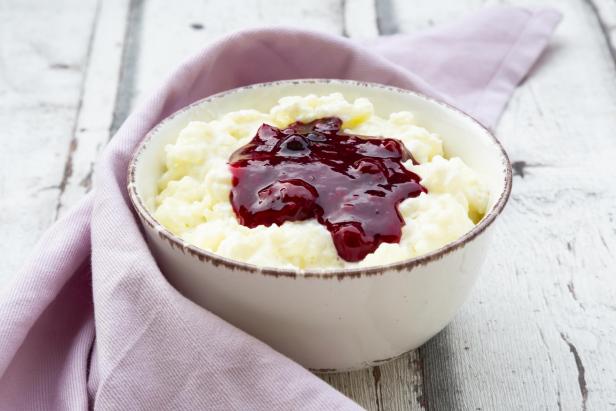 Bowl of rice pudding with cherry and berry groats - Stock-Fotografie