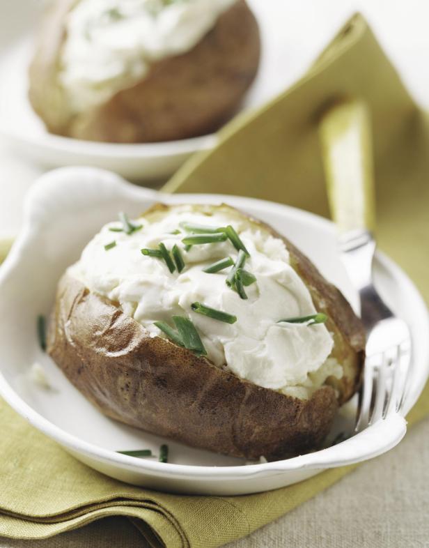 Baked potato with sour cream and chives - Stock-Fotografie