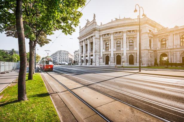 Wiener Ringstrasse, Burgtheater und Straßenbahn bei Sonnenaufgang, Wien, Österreich - Stock-Fotografie