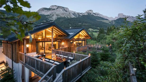 Chalet beleuchtet mit Bergen im Hintergrund