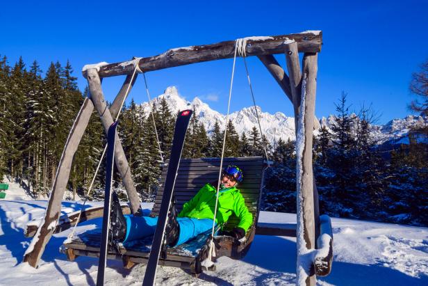 Skifahrer in der Sonne auf einer Schaukel in Filzmoos