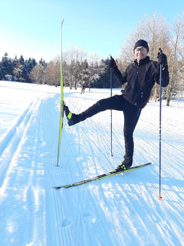 Mann beim Langlaufen im Schnee in der Sonne mit sportlicher Ausrüstung