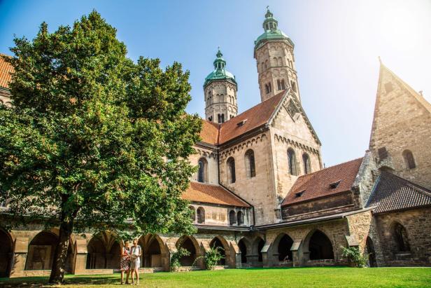 Zwei Frauen im grünen Innenhof einer großen gotischen Kirche