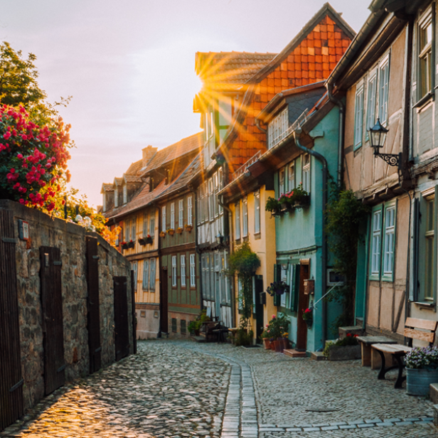 Mittelalterliche Gasse mit Kopfsteinpflaster und bunten Fachwerkhäusern bei Sonnenuntergang