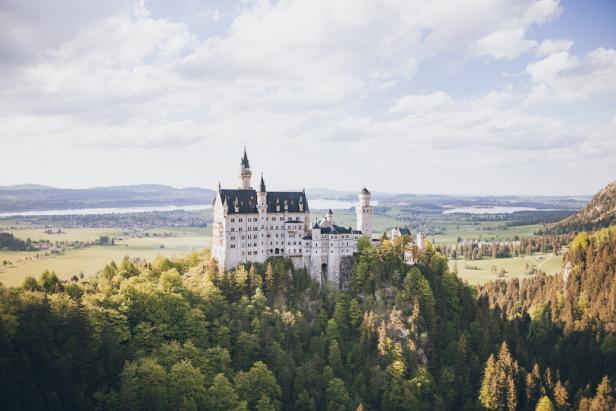 Schloss thront majestätisch auf einem Hügel in malerischer Landschaft