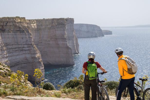 Zwei Radfahrer stehen bei den Sanap-Klippen an der Küste von Gozo